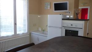 a kitchen with a white refrigerator and a sink at l'ANNEXE in Verdigny