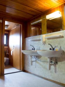een badkamer met twee wastafels aan de muur bij Plan-Francey in Moleson