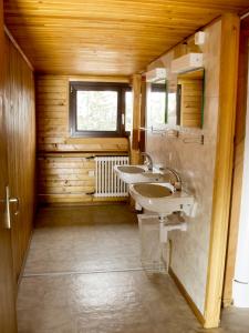uma casa de banho com 2 lavatórios e uma janela em Plan-Francey em Moleson