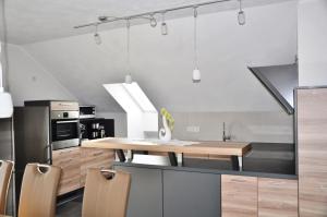eine Küche mit einem Holztisch und einigen Stühlen in der Unterkunft Komfortable Apartment-Wohnung in Fulda