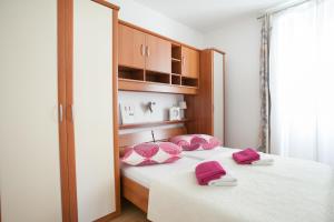 Un dormitorio con una cama con almohadas rosas. en Apartments Goda Center Of Split, en Split