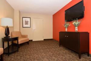a hotel room with a flat screen tv and a chair at Extended Stay America Suites - Jackson - Ridgeland in Ridgeland