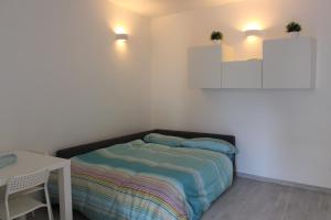 ein kleines Schlafzimmer mit einem Bett und einem Tisch in der Unterkunft Graziella House Holiday in Syrakus