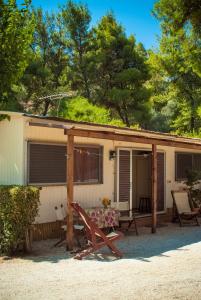 a house with a table and chairs in front of it at XeniCamp & Bungalows in Tolo