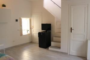 ein Wohnzimmer mit einem TV und einer Treppe in der Unterkunft Graziella House Holiday in Syrakus