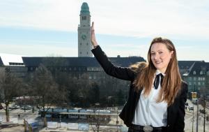 Eine Frau, die vor einem Uhrturm steht. in der Unterkunft Hotel Monopol in Gelsenkirchen