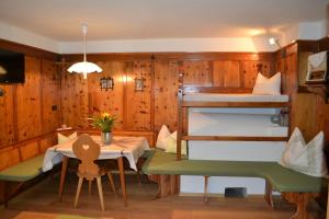 ヴァルダーオラにあるFerienwohnung Pramstallerのテーブルと二段ベッドが備わる客室です。