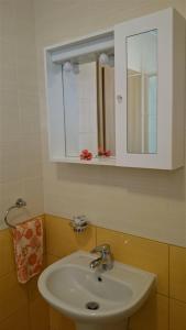 bagno con lavandino bianco e specchio di Holiday Home Julian Alps a Bovec