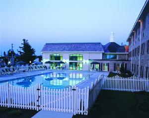 una piscina con una valla blanca frente a un edificio en Bird-in-Hand Family Inn en Bird in Hand