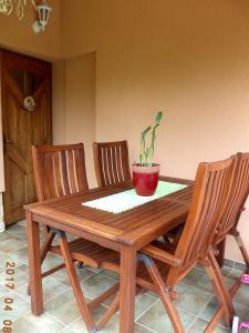 ザラカロシュにあるMargaréta Apartmanの木製テーブル(椅子3脚、鉢植え付)