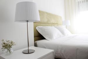 a bedroom with a white bed and a lamp on a table at Bracara Guest House "Bom Jesus" in Braga