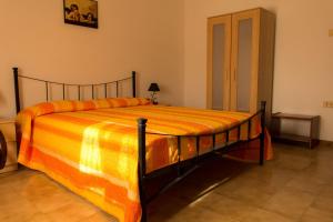 una camera da letto con un grande letto con una coperta arancione di Locazione Turistica Girasole a Porto Tolle