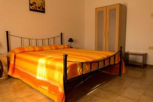 a bedroom with a large bed with an orange blanket at Locazione Turistica Girasole in Porto Tolle