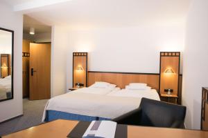 a hotel room with a bed and a desk at Hotel Schere in Northeim