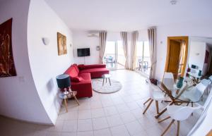 sala de estar con sofá rojo y sillas en Apartment Higuerón, en Fuengirola