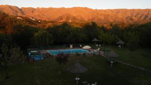 una piscina en un campo con montañas en el fondo en Hotel Terrazas del Rincon en Merlo