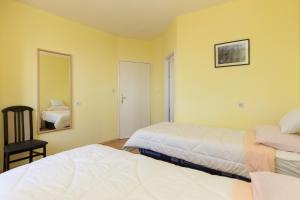 een slaapkamer met twee bedden, een spiegel en een stoel bij Apartment Milic in Dubrovnik