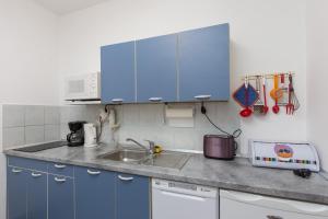 een keuken met blauwe kasten en een wastafel bij Apartment Milic in Dubrovnik