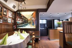 a kitchen with a table, chairs, and a television at Hotel Schere in Northeim