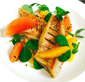 a plate of food with fish and fruit on it at Cumberland Hotel - OCEANA COLLECTION in Bournemouth