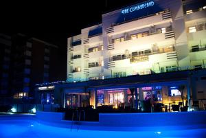 伯恩茅斯的住宿－坎伯蘭海洋休閒酒店，一座建筑,在晚上前方有一个游泳池