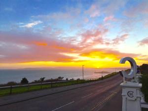 an empty road with the sunset in the background at Cumberland Hotel - OCEANA COLLECTION in Bournemouth