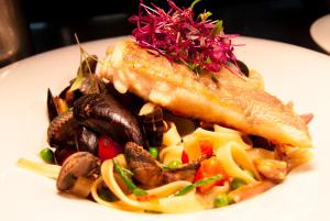 a white plate of food with seafood and vegetables at Cumberland Hotel - OCEANA COLLECTION in Bournemouth