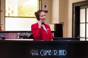 a woman is talking on a cell phone at Cumberland Hotel - OCEANA COLLECTION in Bournemouth