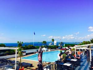 a view of a pool at a resort with tables and chairs at Cumberland Hotel - OCEANA COLLECTION in Bournemouth