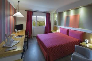 a hotel room with a bed and a desk and a computer at Locanda Dell'Angelo in Ameglia
