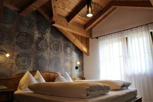 - une chambre avec un grand lit et un plafond en bois dans l'établissement Gartenresidence Stephanie by Hotel Rotwand, à Laives