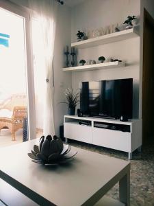 a living room with a flat screen tv and a table at Seaside romantic apartment in Algarrobo-Costa