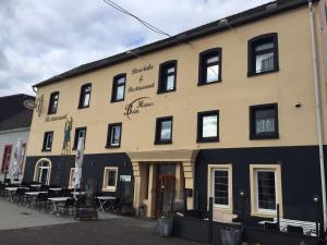 a building with tables and chairs in front of it at Beim Heines in Daun