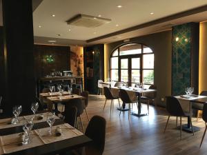 un comedor con mesas y sillas y una ventana en Hotel Comillas, en Comillas