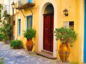 a building with a red door and two vases with plants at Casa Vittorio in Lipari