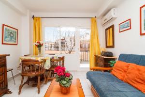 ein Wohnzimmer mit einem blauen Sofa und einem Tisch in der Unterkunft Coronado 116 Apartments Casasol in Nerja