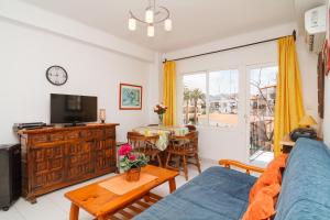ein Wohnzimmer mit einem Sofa und einem TV in der Unterkunft Coronado 116 Apartments Casasol in Nerja