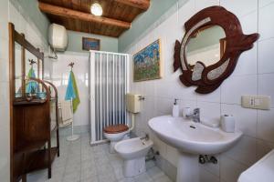 a bathroom with a sink and a toilet and a mirror at Le Terrazze di Angela in Marina di Ragusa +20 photos