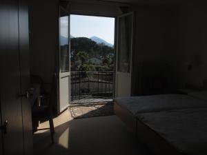 una camera da letto con porta che si apre su un balcone con vista di Hotel Arcadia ad Ascona