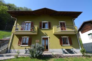 a yellow house with two balconies on the side at Ca' del Michelàs in San Pellegrino Terme