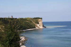 a view of a beach with a lighthouse on a cliff at Meerzauber in Altenkirchen