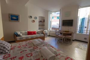 モンテロッソ・アル・マーレにあるAppartamento Burancoのベッドルーム1室(ベッド1台付)、リビングルームが備わります。