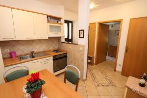 a kitchen with a table and chairs and a counter top at Altstadt in Lovran