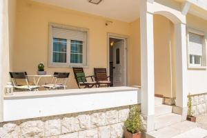 a front porch with chairs and a table at Vivenda Remos in Sesimbra