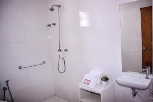 a white bathroom with a shower and a sink at Prime Hotel in Feira de Santana