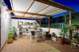 a patio with a table and chairs and potted plants at Le Terrazze di Angela in Marina di Ragusa