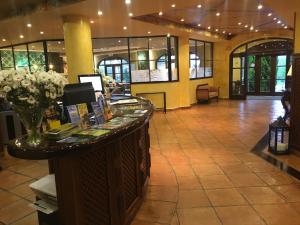 a lobby with a counter with flowers on it at Hotel Comillas in Comillas