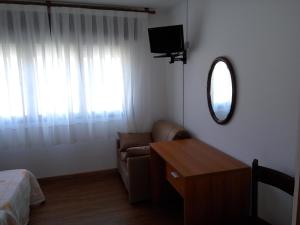 a room with a couch and a window with a mirror at Hostal Carabela in Areas