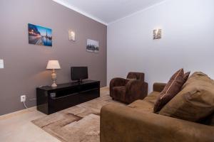 sala de estar con sofá y TV en Dunas do Alvor, en Alvor