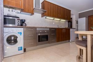 cocina con lavadora y microondas en Dunas do Alvor, en Alvor